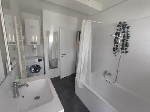 a white bathroom with a sink and a shower at Wohnen bei frau tinz - Studio - Bahnhof- und Zentrumsnähe in Neunkirchen