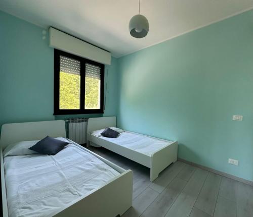 a bedroom with two beds and a window at Mafiolina d'Amare in Marina di Massa