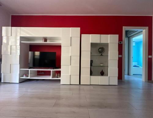 a living room with a tv and a red wall at Mafiolina d'Amare in Marina di Massa