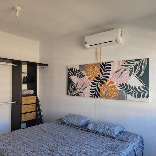 a bedroom with a bed and a picture on the wall at Casa Puerta al Sol Acapulco - Club de Playa in Acapulco
