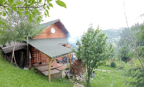 a log cabin with smoke coming out of it at Cabana Dor De Munte in Muntele Rece