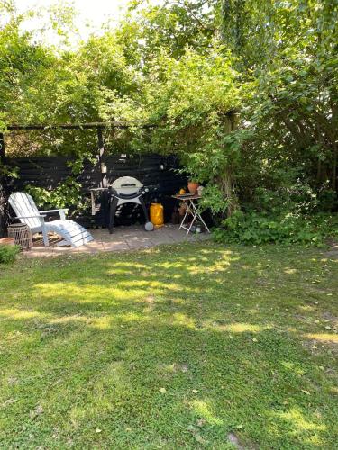 a backyard with a table and chairs in a yard at 5 min from the water's edge in Strøby