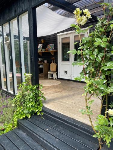 an open door of a house with a wooden deck at 5 min from the water's edge in Strøby