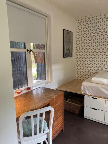 a bedroom with a desk and a bed and a window at 5 min from the water's edge in Strøby