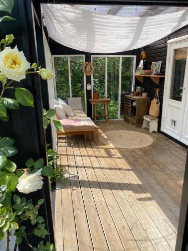 a screened in porch with a couch and a table at 5 min from the water's edge in Strøby
