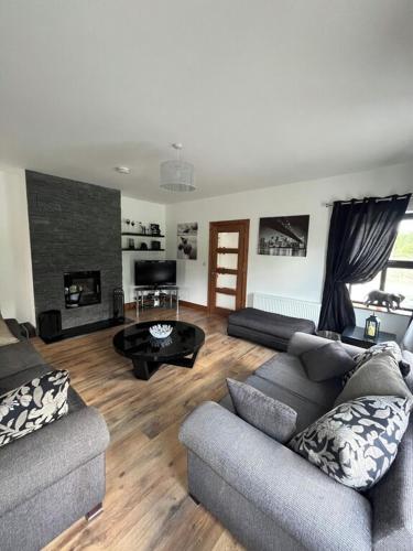 a living room with two couches and a fireplace at Fabulous 4 Bedroom House, Gateway to Connemara in Galway