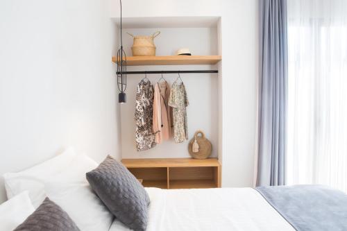 a bedroom with a white bed and a window at Calmare suites in Rethymno Town