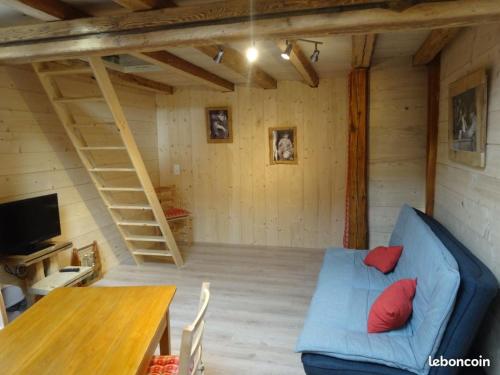 un salon avec un canapé bleu et une table dans l'établissement Gite 2-3 personnes Arçon proche Pontarlier, à Arçon
