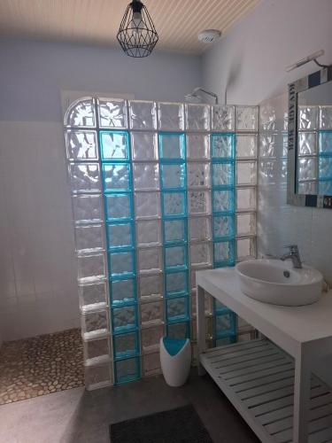 La salle de bains est pourvue d'un mur en verre et d'un lavabo. dans l'établissement Maison Familiale avec Piscine Noirmoutier 800 m Plage de Luzeronde, à Noirmoutier-en-l'lle