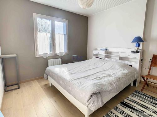 une chambre avec un lit blanc et une fenêtre dans l'établissement Maison Familiale avec Piscine Noirmoutier 800 m Plage de Luzeronde, à Noirmoutier-en-l'lle