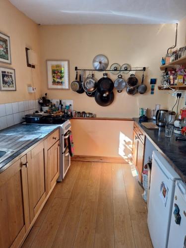 a kitchen with wooden floors and pots and pans on the wall at 2 White Horse Cottages in Washford