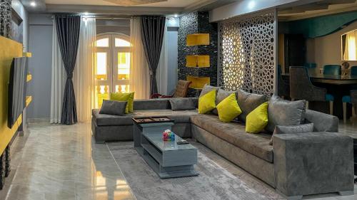 ein Wohnzimmer mit einem braunen Sofa und gelben Kissen in der Unterkunft El Obour Home - العبور in Obour
