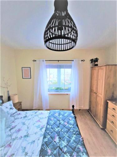 a bedroom with a bed and a chandelier at No1 Harbour view apartment Killybegs in Killybegs