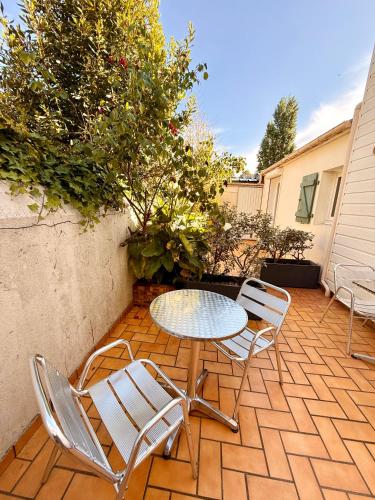 a patio with a table and chairs on a patio at Alizé Studio COSY dans résidence Privée avec Patio à proximité in Saint-Nazaire