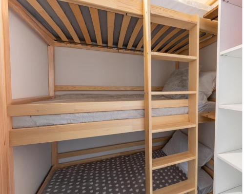Cette chambre comprend des lits superposés en bois. dans l'établissement Appartement 6pers dont 4 adultes max aux Orres 1800, aux Orres