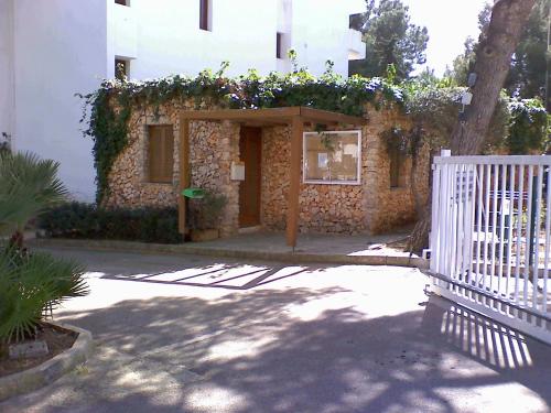 a building with a white fence in front of it at Sea frontline Apartment 'Faraona'. Pool. WIFI in Santanyi