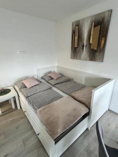 a bed with two pillows on it in a room at Apartman L, SELF CHECK IN, FREE PARKING in Karlovac
