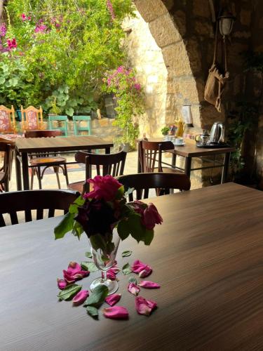 a vase of flowers sitting on a table with roses at Hartna zaman in Taiyiba