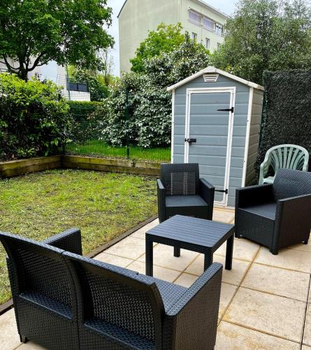 un patio avec des chaises, une table et un hangar dans l'établissement Villeurbanne Super Apartment in residence, à Villeurbanne