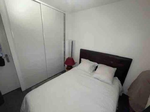 a bedroom with a white bed and a red lamp at Villeurbanne Super Apartment in residence in Villeurbanne