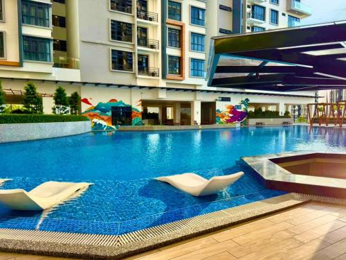 a swimming pool with two white chairs in a building at K avenue family room by TZ homestay in Donggongon