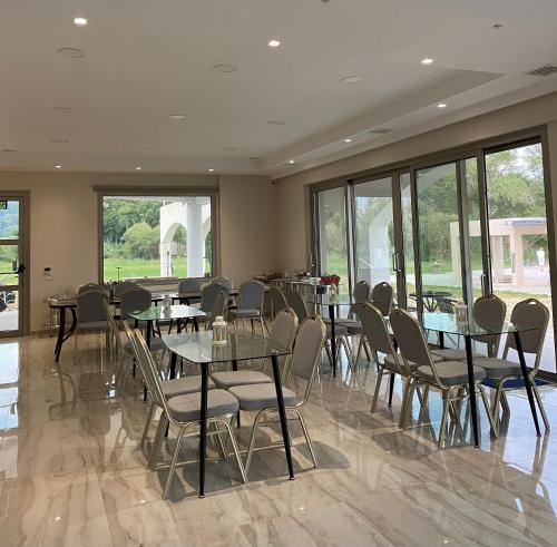 a dining room with tables and chairs and windows at Vians Olympia Resort in Olympia