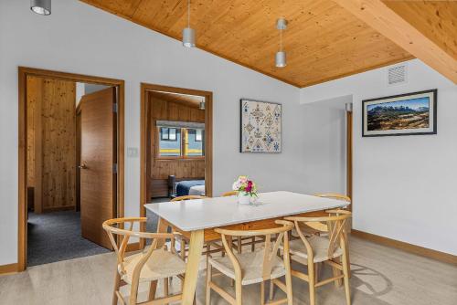 a dining room with a white table and chairs at Alps #201- LEED Gold Certified & Dog Friendly in Canmore