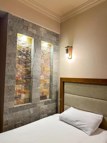 a bedroom with a bed and a stone wall at Sunset Luxury Dahab in Dahab
