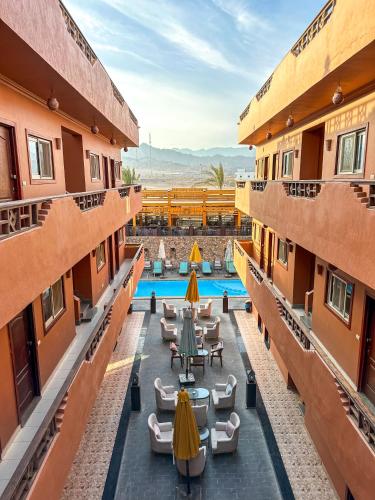 a view of the courtyard of a hotel with tables and chairs at Sunset Luxury Dahab in Dahab