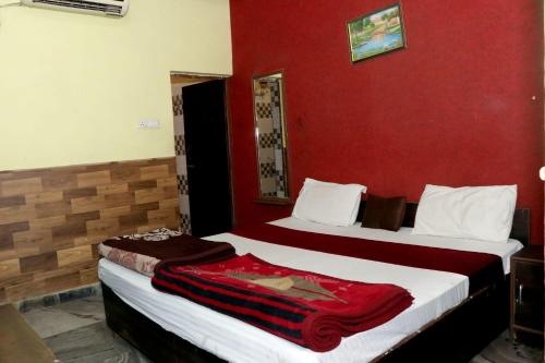 two beds in a room with red walls at awesome family homestay in Agra