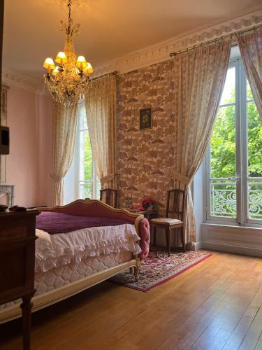 une chambre avec un lit et un lustre dans l'établissement Demeure des Payratons, à Saint-Gérand-le-Puy