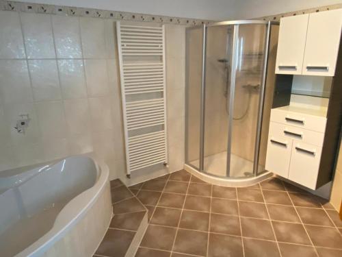 a bathroom with a bath tub and a shower at Haus ElSaVi - Top 1 in Köstendorf