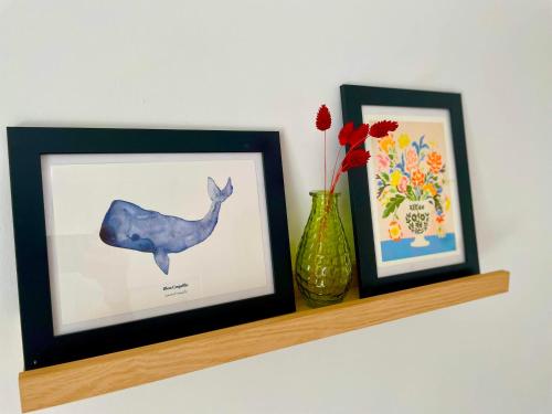 a shelf with two pictures and a vase on it at Studio centre Rennes in Rennes