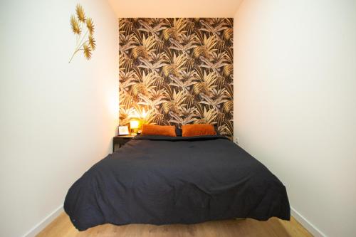 - une chambre avec un lit noir et du papier peint dans l'établissement Le Terracotta, plein centre, garage, WIFI-Netflix, à Montbéliard