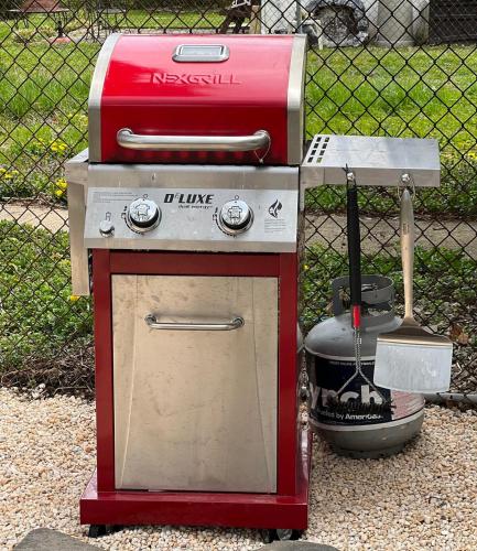 a red barbecue grill sitting in front of a fence at Cozy 3 Bedroom Home in Historic Kennett Square in Kennett Square
