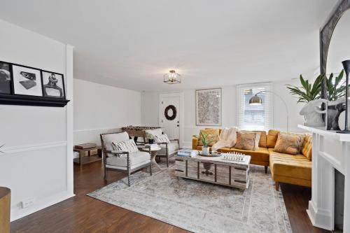 a living room with a yellow couch and chairs at Cozy 3 Bedroom Home in Historic Kennett Square in Kennett Square