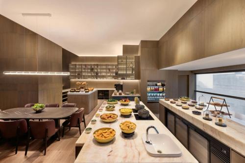 a kitchen with a long table with food on it at JW Marriott Auckland in Auckland