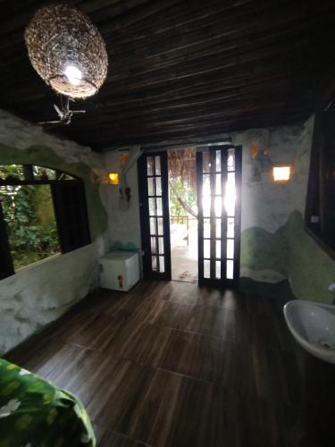 a room with two doors and a wooden floor at Filhas da Terra Jaguanum in Itacuruçá