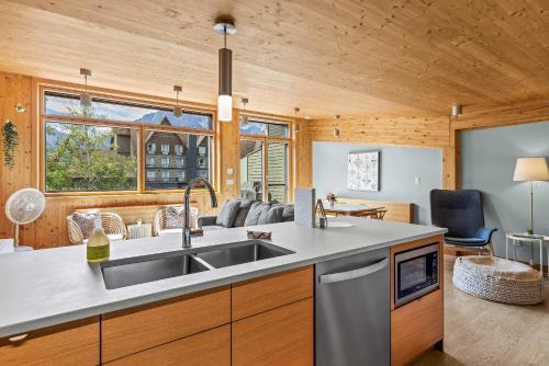 a kitchen with a sink and a living room at Dolomites #203 - LEED Gold Certified in Canmore