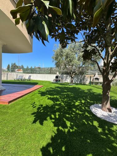 a tree in the middle of a green yard at Marina Residence Apartment 603 in Portorož