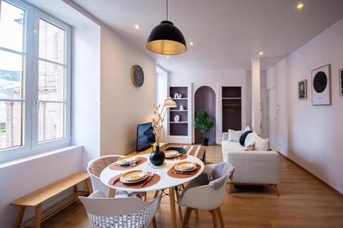 Un comedor y una sala de estar con mesa y sillas. en Le Céleste, Centre Historique, WIFI-Netflix, en Belfort