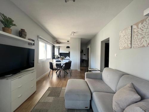 a living room with a couch and a flat screen tv at Cozy City Nest, Heart of Limassol in Limassol