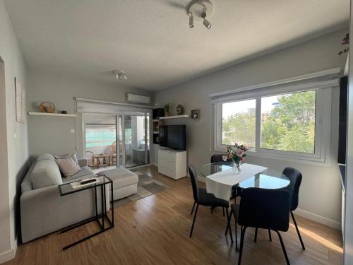a living room with a couch and a table with chairs at Cozy City Nest, Heart of Limassol in Limassol