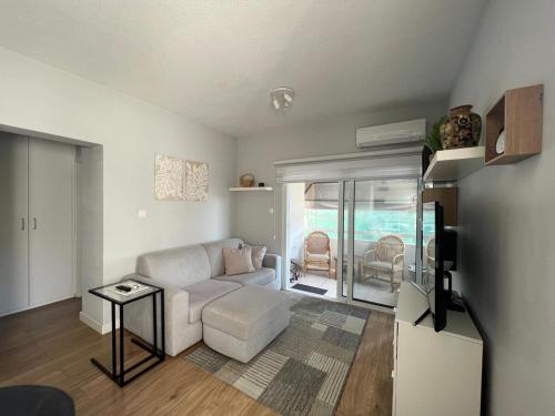 a living room with a white couch and a table at Cozy City Nest, Heart of Limassol in Limassol
