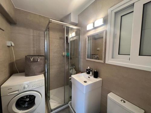 a small bathroom with a washing machine and a sink at Cozy City Nest, Heart of Limassol in Limassol