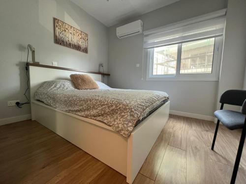 a bedroom with a bed and a window and a chair at Cozy City Nest, Heart of Limassol in Limassol