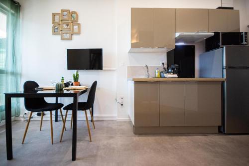 une cuisine et une salle à manger avec une table et des chaises dans l'établissement L'Escale, Proche ville, Parking, Terrasse, Netflix, à Montbéliard