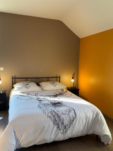 a bedroom with a large bed with white sheets at Le Daguet in Florenville