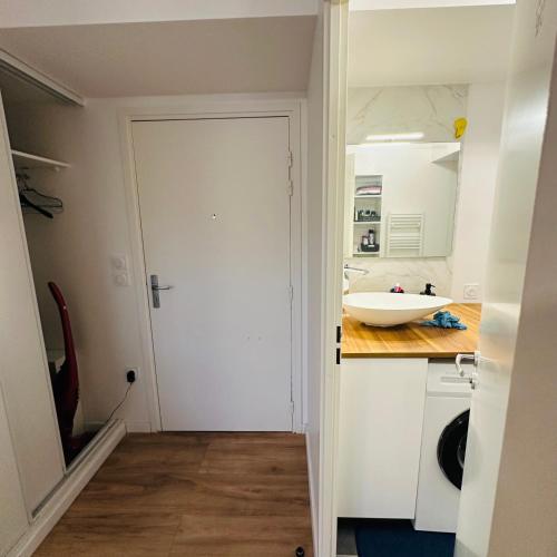 a kitchen with a white door and a sink at Appartement deux pièces cosy in Asnières-sur-Seine