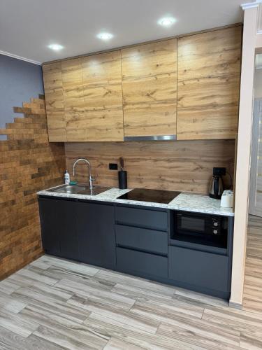 a kitchen with a sink and wooden cabinets at Guest House Zatyshnyi Dvir in Bukovel